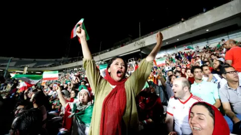 Getty Images An Iranian woman cheers while watching the World Cup Group B soccer match between Portugal and Iran at Azadi stadium in Tehran on June 25, 2018.