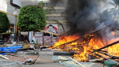 Security forces break up a sit-in by supporters of Mohammed Morsi in Cair's al-Nahda Square (14 August 2013)