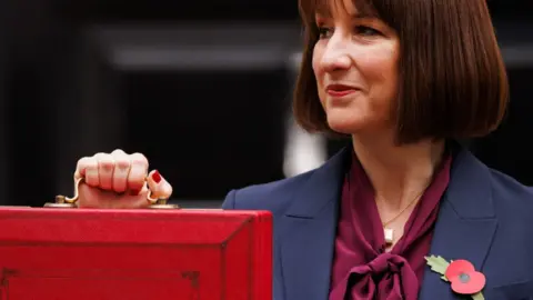 The Chancellor Rachel Reeves poses with the red box outside Number 11 Downing Street before delivering her first Budget on 30 October 2024