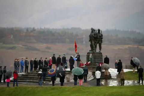 PA Media A small number of serving and former Royal Marine Commandos at the Commando Memorial at Spean Bridge, near Fort William, for the annual Remembrance Sunday ceremony
