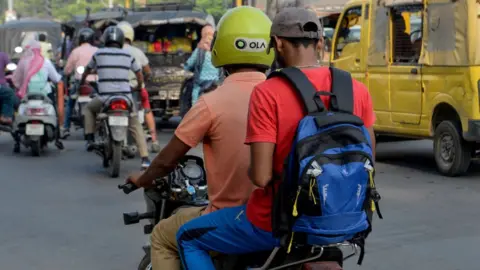 Getty Images In this photograph taken on September 12, 2019, an Ola motorcyclist transports a passenger in Amritsar