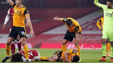 BBC Raúl Jiménez lying on the floor of the pitch after suffering the injury, as other players wave over help