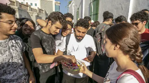 Getty Images A student handing out sweets before baccalaureate exams at the Sadiki High School in Tunis, Tunisia - Wednesday 8 June 2022