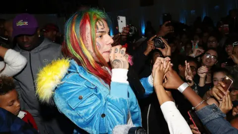 Getty Images Rapper 6ix9ine performing in New York in December 2017. Known for colourful hair