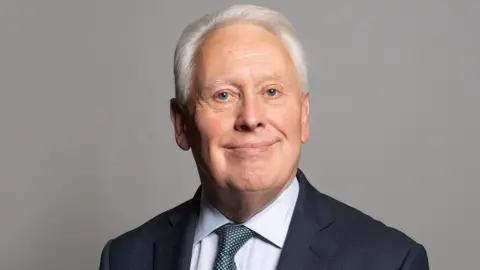 UK Parliament Sir Bob Neill smiling in official photo