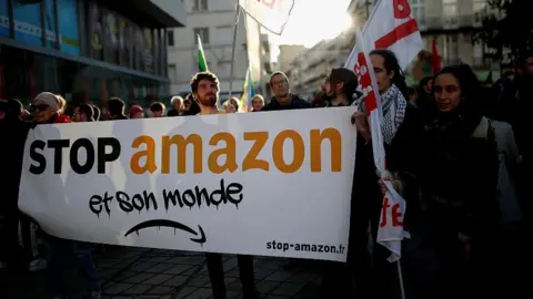 Reuters Activists hold a banner that reads: "Stop Amazon and its world" as they demonstrate in Nantes, France, November 29, 2019