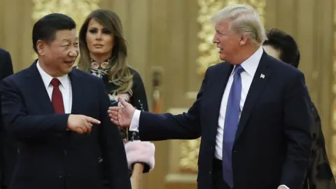 Getty Images Xi Jinping, left, points at Donald Trump smiling