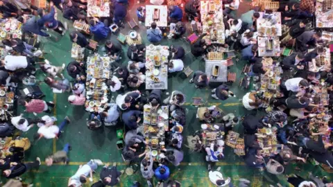 Getty Images A barbecue restaurant in Zibo is packed with diners as long queues of customers wait for vacant tables