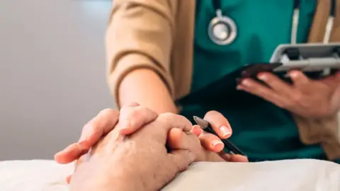 Getty Images File picture of doctor holding patient's hand