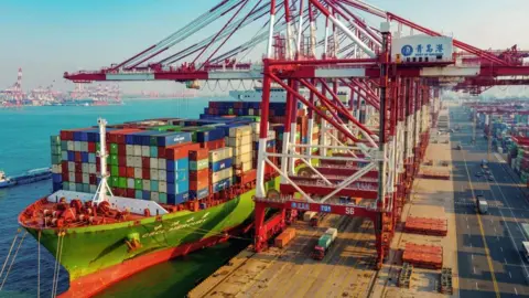 STR/AFP/Getty Images A cargo ship loaded with containers berths at a port in Qingdao in China's eastern Shandong province