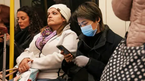 PA Media Person on the tube wearing a mask