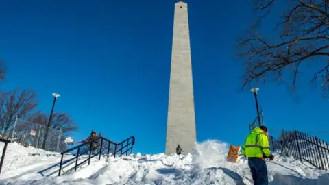 Getty Images A worker clears snow away from the base of the Bunker Hill memorial