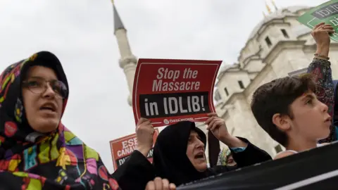 AFP Turkish women hold of posters and chant slogans against the possible Syrian government offensive on Idlib province, at a protest in Istanbul (7 September 2018)