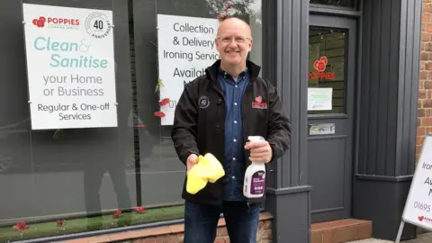 Chris Wootton The boss of cleaning firm Poppies, Chris Wootton holding a spray bottle and sponge