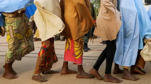 Reuters Girls who were kidnapped from a boarding school in the north-west Nigerian state of Zamfara walk in line after their release, in Zamfara, Nigeria -2 March 2021