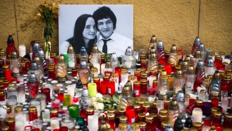 AFP/Getty Images Hundreds of candles have been placed in front of a portrait of Slovak investigative journalist Jan Kuciak and his girlfriend Martina Kusnirova