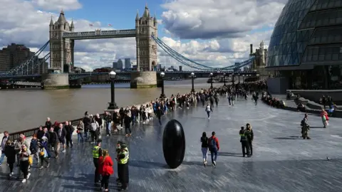 PA Media The queue passes Tower Bridge