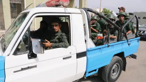 Reuters Police patrol a street in the Red Sea port city of Hudaydah (13 February 2019)