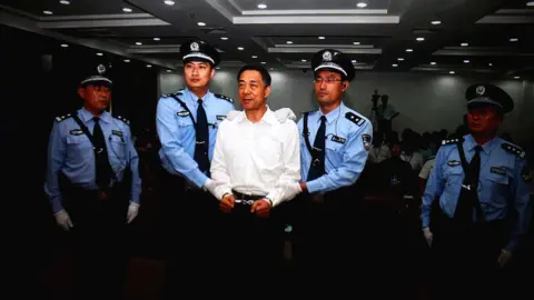 Getty Images A screen shows the picture of the sentence of Chinese politician Bo Xilai (Center) on September 22, 2013 in Beijing, China.