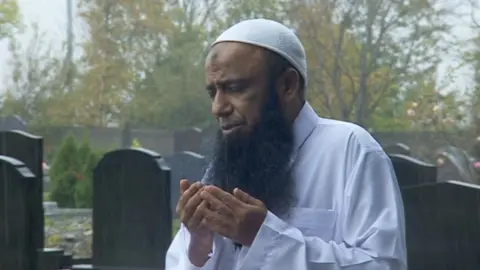 BBC Dr Muhammad Taufiq prays at the graves
