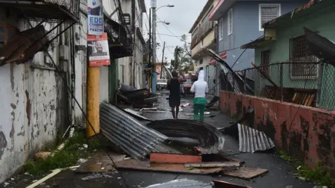 Getty Images Men survey the damage caused by Hurricane Maria in San Juan, Puerto Rico.