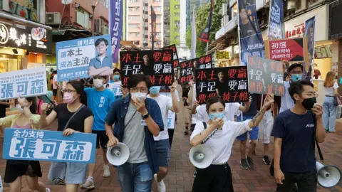 Reuters Candidates march on a street to campaign for the primary elections in Hong Kong