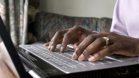 BBC Unidentified woman typing on laptop computer