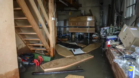 Dan Rowlands/SWNS.com Coffins float around inside a flooded funeral parlour in Fishlake