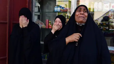 EPA Iraqis mourn during the funeral of a protester killed in clashes with security forces in Baghdad (5 October 2019)