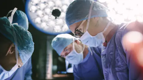 Getty Images Surgeons in an operating theatre.