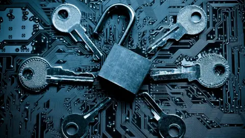 Getty Images Open padlock surrounded by keys on circuit board