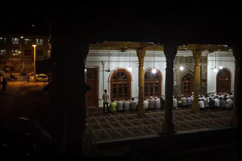 Getty Images Uyghur men pray at an open air mosque on July 31, 2014 in old Kashgar, Xinjiang Uyghur Autonomous Region, China.