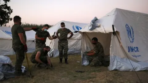 Reuters Soldiers set up tents on Moria