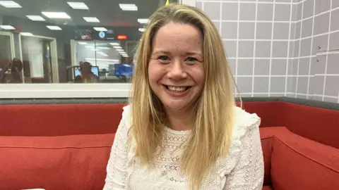 Lucy Stockall from Bristol After Stroke sitting on a red sofa