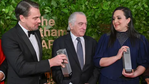 Getty Images Leonardo DiCaprio, Robert De Niro and Lily Gladstone pose with the Gotham Historical Icon & Creator Tribute for "Killers of the Flower Moon" at the 33rd Annual Gotham Awards