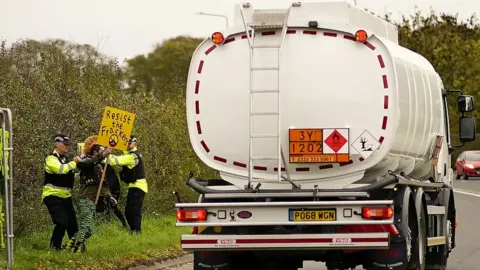 Getty Images Police detain protestors near a lorry