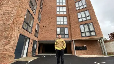 Essex Fire and Rescue Service Area manager Jim Palmer from the fire service stands in front of the seven storey brick flat building.