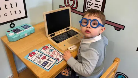 Four year old Teddy with a toy computer