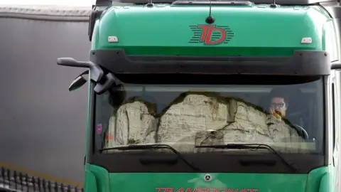 PA Media The White Cliffs are reflected in the windscreen of a lorry whilst the driver queues to enter the port of Dover in Kent