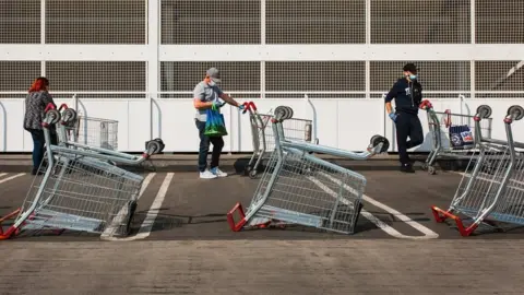 Michaela Strivens People queue outside supermarket