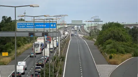 Police escort vehicles across the Prince of Wales Bridge, which runs between England and Wales