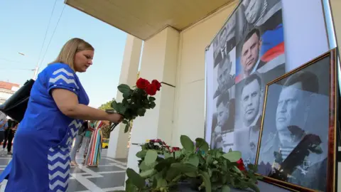 Reuters A woman places flowers to commemorate the leader of the separatist self-proclaimed Donetsk People's Republic Alexander Zakharchenko, 1 September 2018
