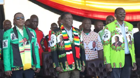 EPA Zimbabwean President Emmerson Mnangagwa (C) before addressing thousands of supporters who had gathered at White City Stadium in Bulawayo, Zimbabwe