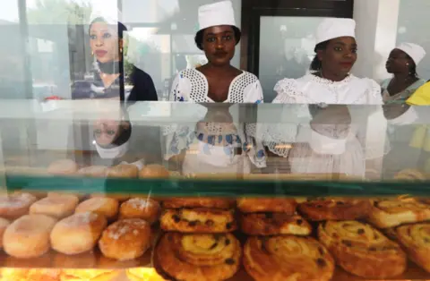 Reuters Vendors stand behind a display of pastries at O'Merveilles in Touba, Senegal, on 10 June.