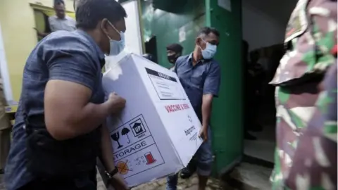 EPA Workers unload boxes containing a COVID-19 vaccine from a truck to a storage building, upon the arrival of Sinovac"s COVID-19 vaccine in Banda Aceh, Indonesia, 12 January 2021. I