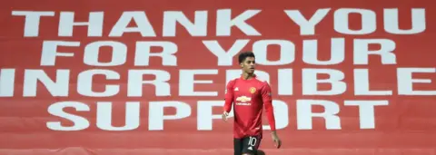 PA Media Marcus Rashford in front of a banner which reads: Thank you for your incredible support