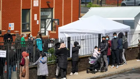 Christopher Furlong People queue for Covid-19 vaccinations at a mobile vaccination clinic set up at the Masjid E Sajedeen Mosque in Blackburn, England.