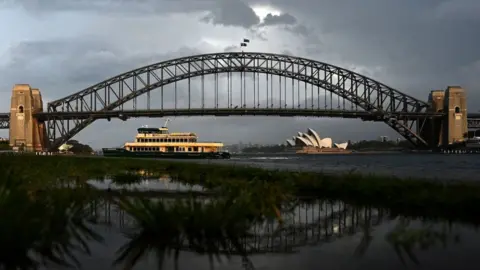 Getty Images A public ferry makes its way across Sydney Harbour during thundery weather in Sydney