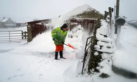 PA Media A man clears a snow drift in Lanehead, County Durham, 21 January 2021