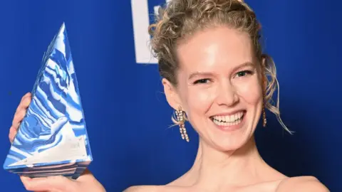 Getty Images Rosy McEwen holding her best lead performance trophy at the British Independent Film Awards in December